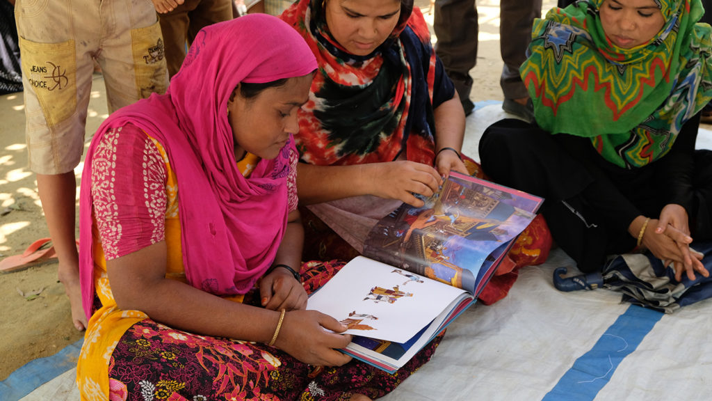 Deux adultes rohingyas lisent des livres